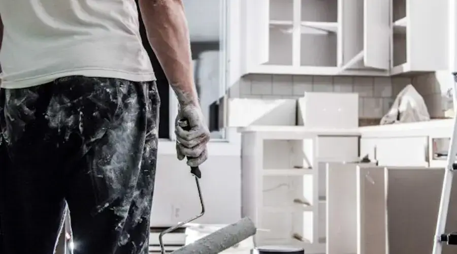 Man painting renovated kitchen