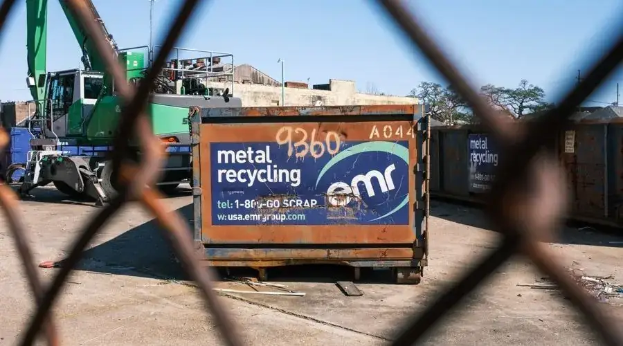 View of dumpster container through a fence